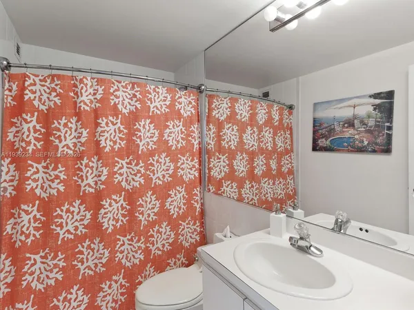 a bathroom with a sink toilet and a mirror