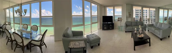 a dining room with furniture and a floor to ceiling window