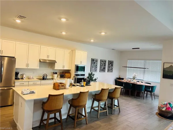 a kitchen with a dining table chairs and refrigerator