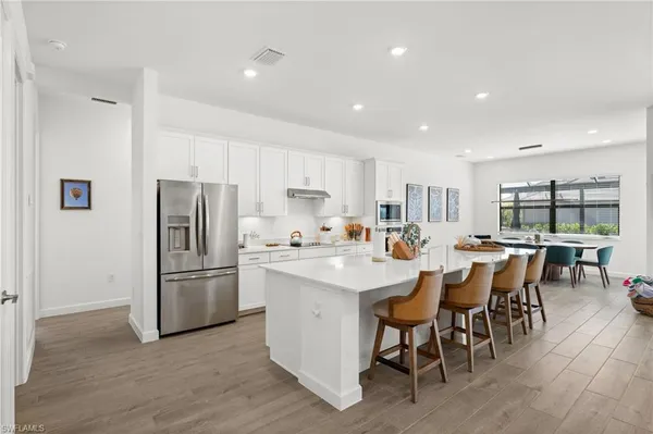 a kitchen with refrigerator and chairs