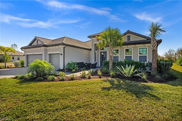 a view of a house with a small yard and potted plants