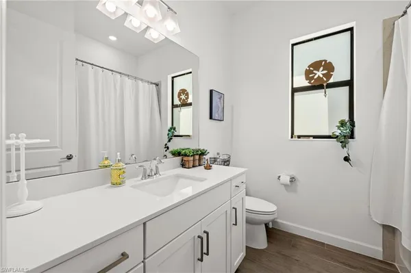 a bathroom with a sink a toilet and a mirror