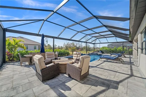 a view of a patio with couches and chairs under an umbrella
