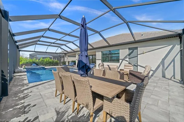 a view of a patio with a table and chairs under an umbrella