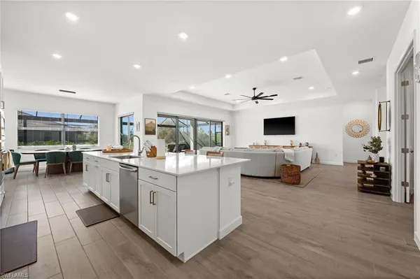 a large white kitchen with a large window and furniture