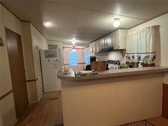 a kitchen with stainless steel appliances granite countertop a stove a sink dishwasher and a microwave oven with wooden floor