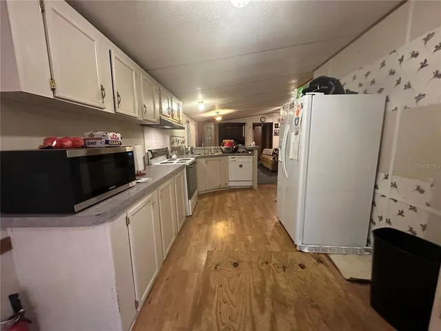 a view of a hallway with workspace and a living room