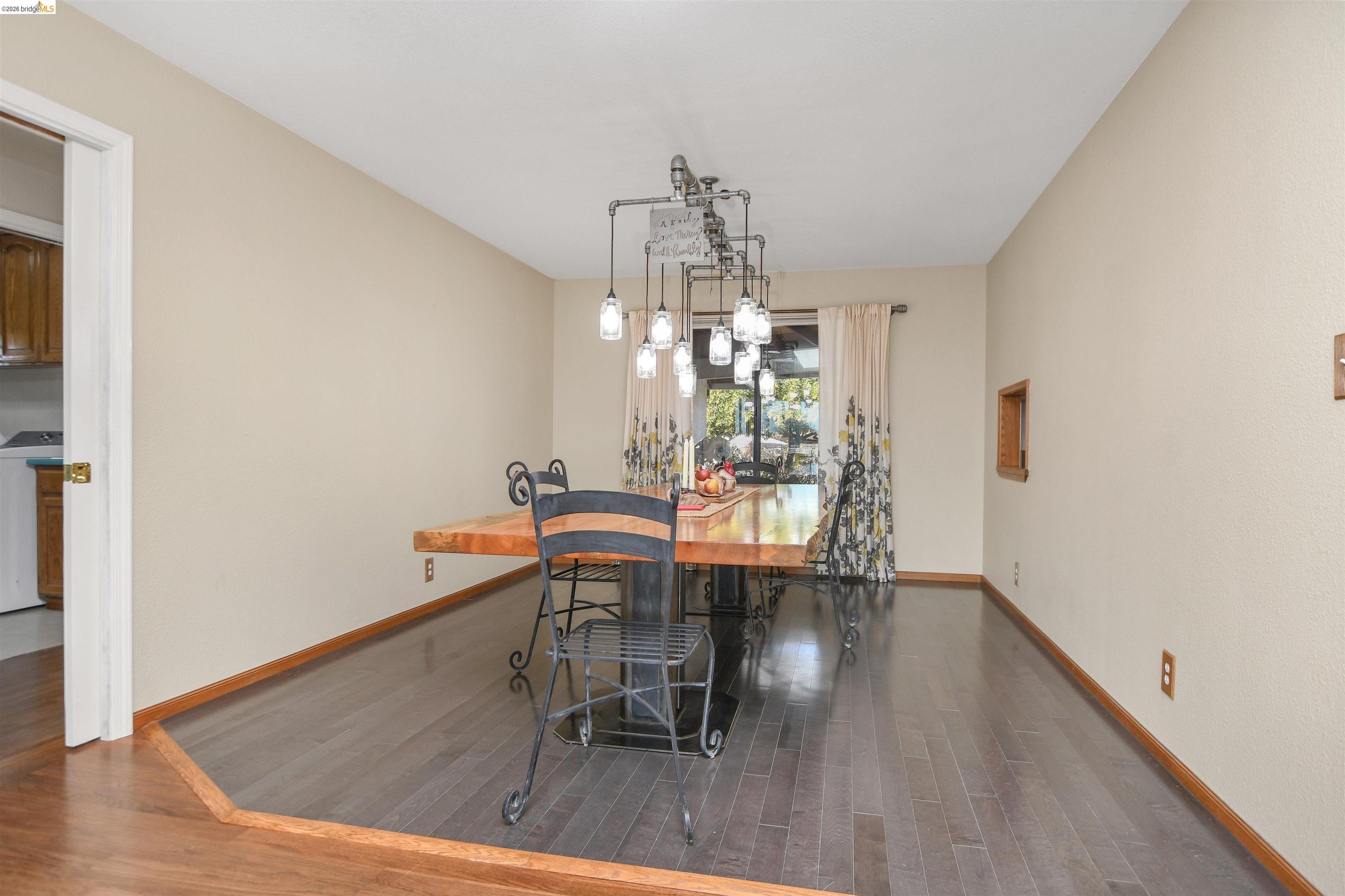 23751 Marsh Creek Road Brentwood, CA 94513 - Photo 15 of 49 a dining room with wooden floor a chandelier a glass table and chairs