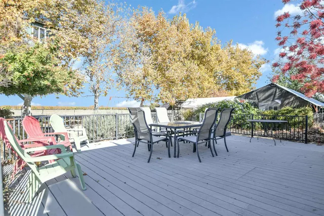 a table and chairs with the view of tree in the background