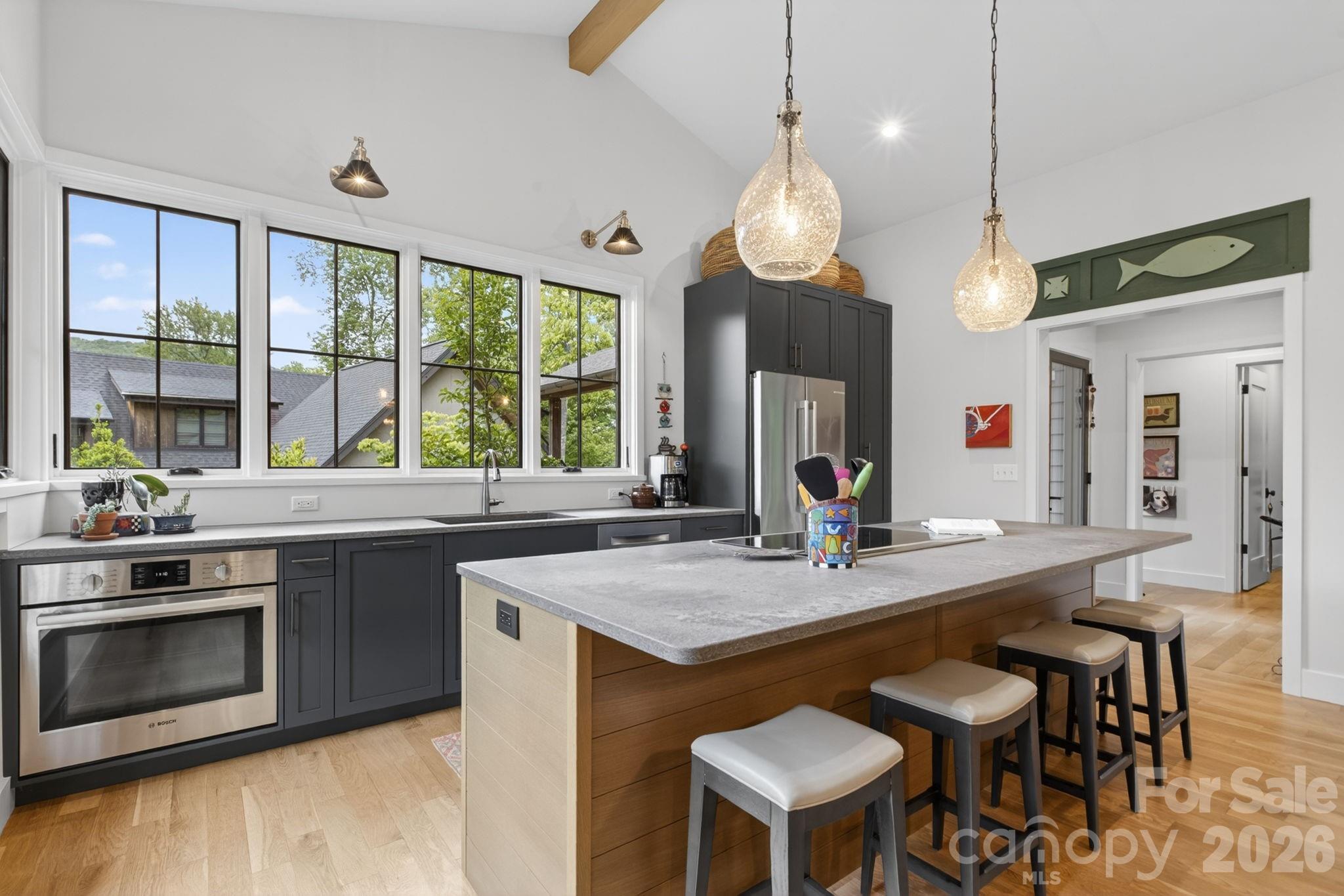18 Wordsworth Road Black Mountain, NC 28711 - Photo 6 of 23 a open kitchen with stainless steel appliances granite countertop a stove a sink dishwasher a dining table and chairs with wooden floor