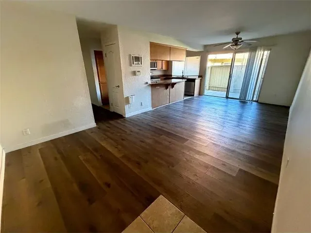 a view of a kitchen with wooden floor and electronic appliances