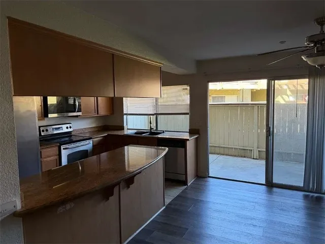 a kitchen with granite countertop a refrigerator and a stove top oven