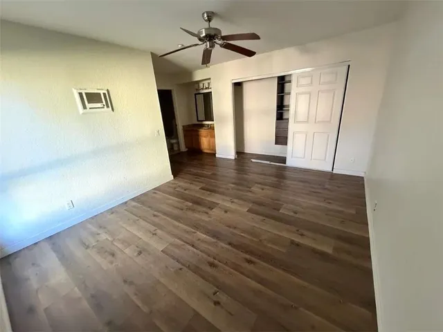a view of a livingroom with wooden floor and a ceiling fan