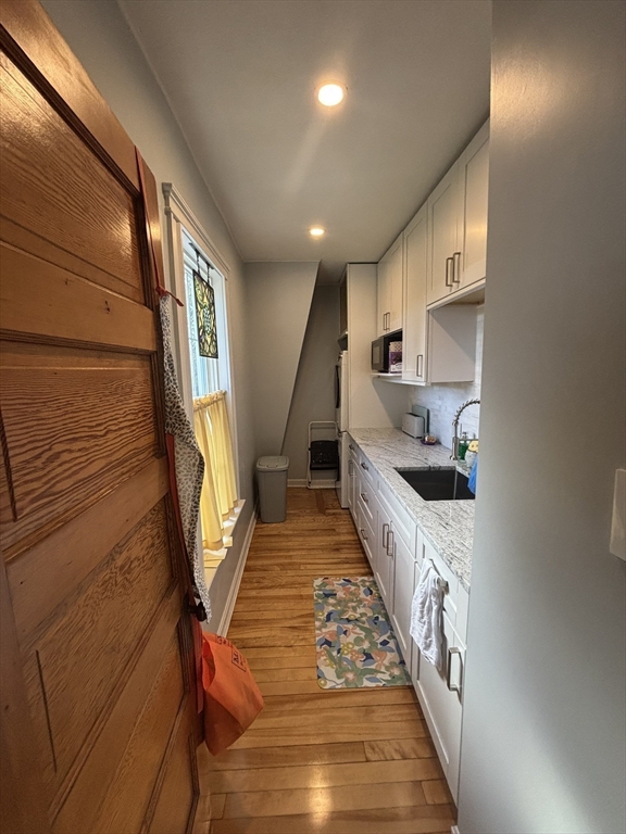 460 Burncoat Street, Unit B Worcester, MA 01606 - Photo 7 of 19 a hallway with white cabinets and wooden floor