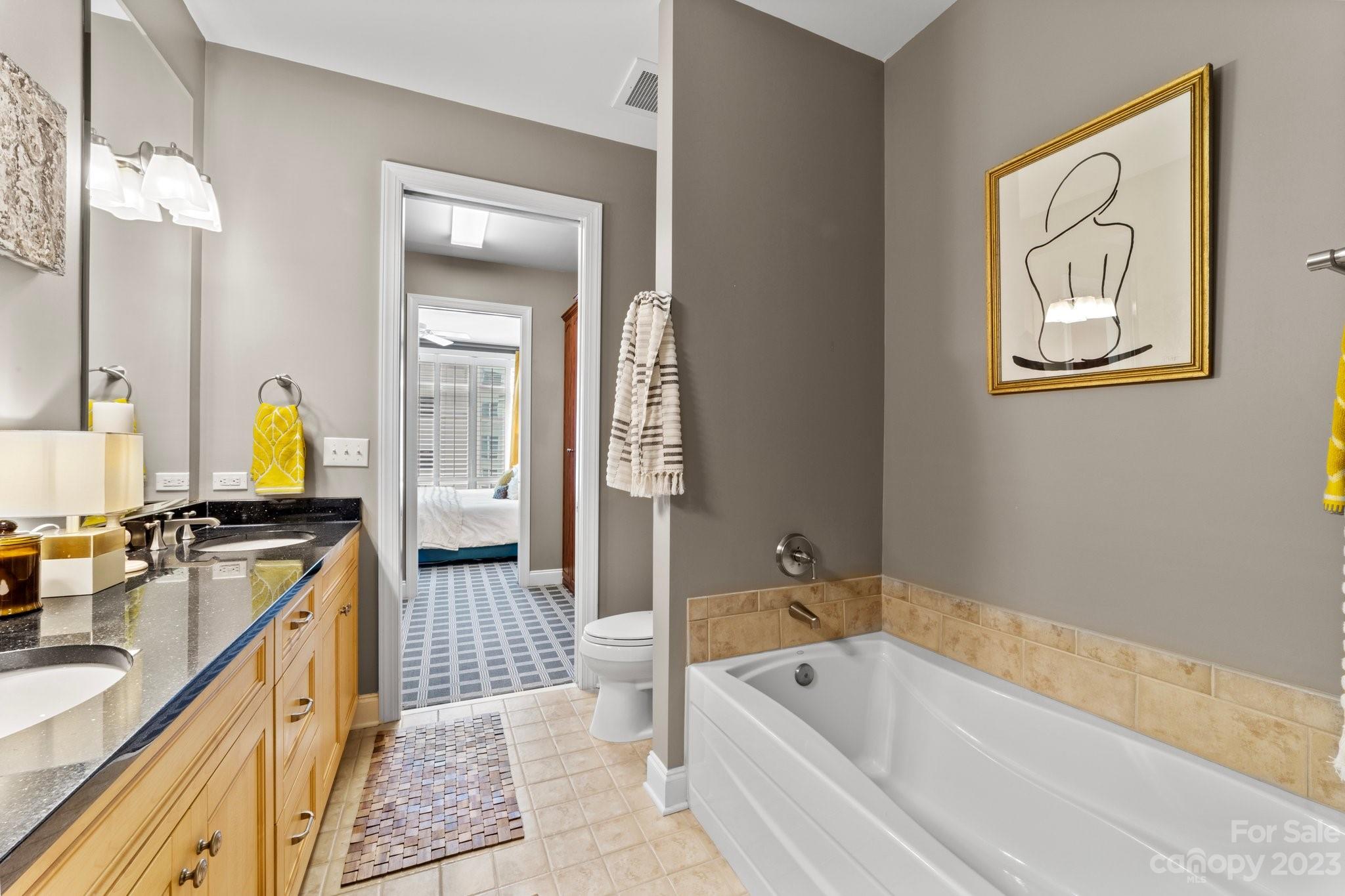 230 South Tryon Street, Unit 906 Charlotte, NC 28202 - Photo 17 of 27 a spacious bathroom with a tub sink and mirror