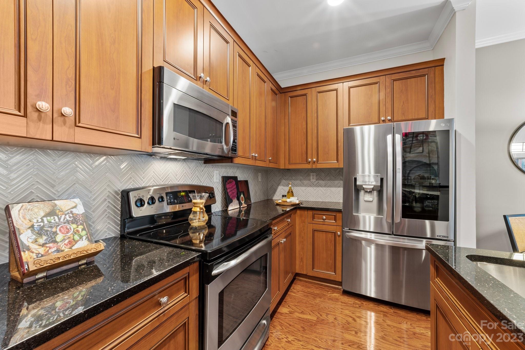 230 South Tryon Street, Unit 906 Charlotte, NC 28202 - Photo 4 of 27 a kitchen with stainless steel appliances granite countertop a refrigerator stove and sink