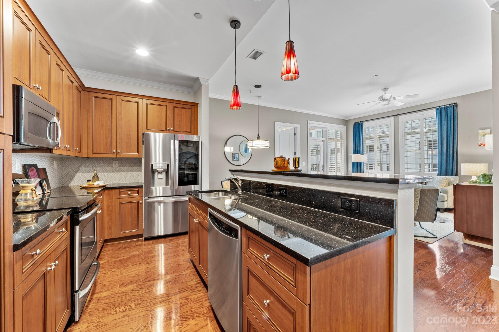 230 South Tryon Street, Unit 906 Charlotte, NC 28202 - Photo 6 of 27 a kitchen with stainless steel appliances granite countertop a stove and a sink