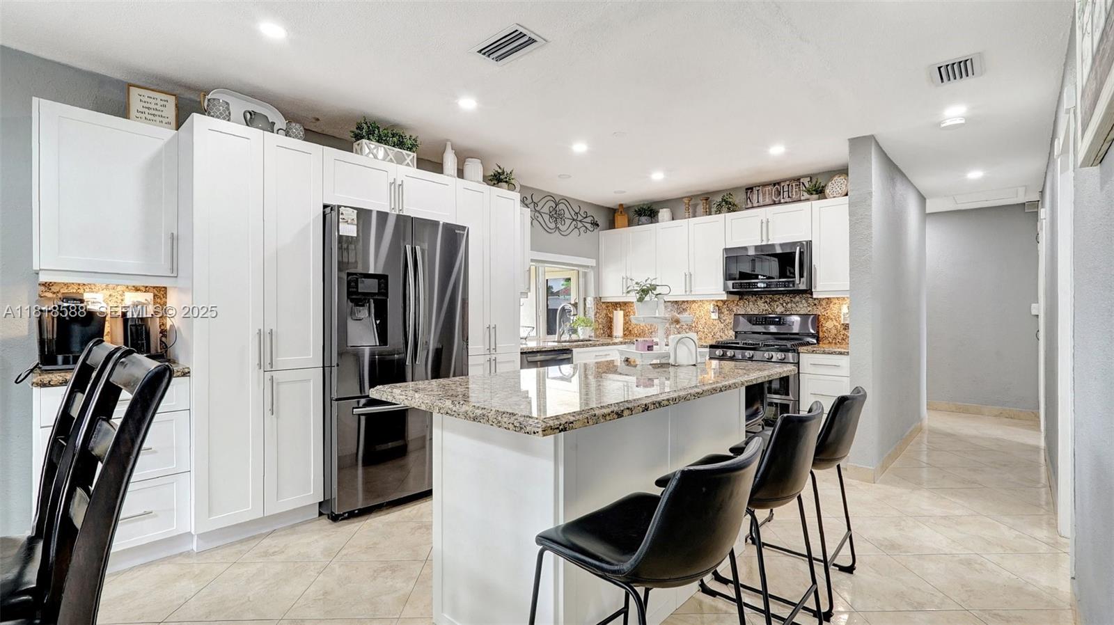 8540 Northwest 182nd Street Hialeah, FL 33015 - Photo 12 of 63 a kitchen with kitchen island a appliances dining table and chairs