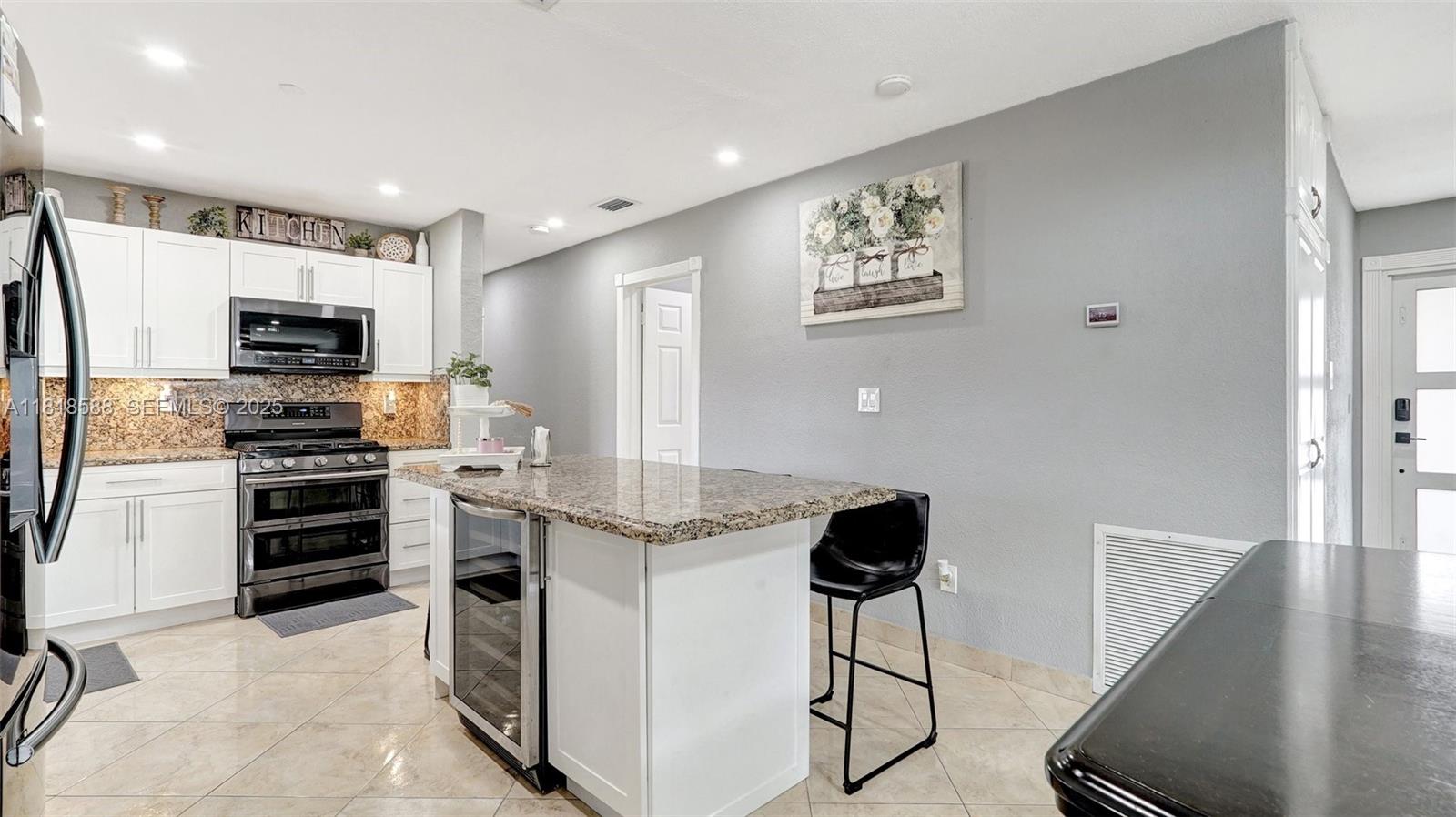 8540 Northwest 182nd Street Hialeah, FL 33015 - Photo 13 of 63 a kitchen with stainless steel appliances kitchen island a refrigerator stove and microwave