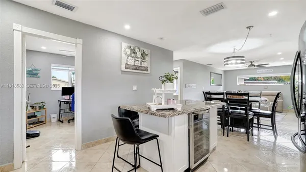 a kitchen with stainless steel appliances kitchen island granite countertop a refrigerator and a stove top oven