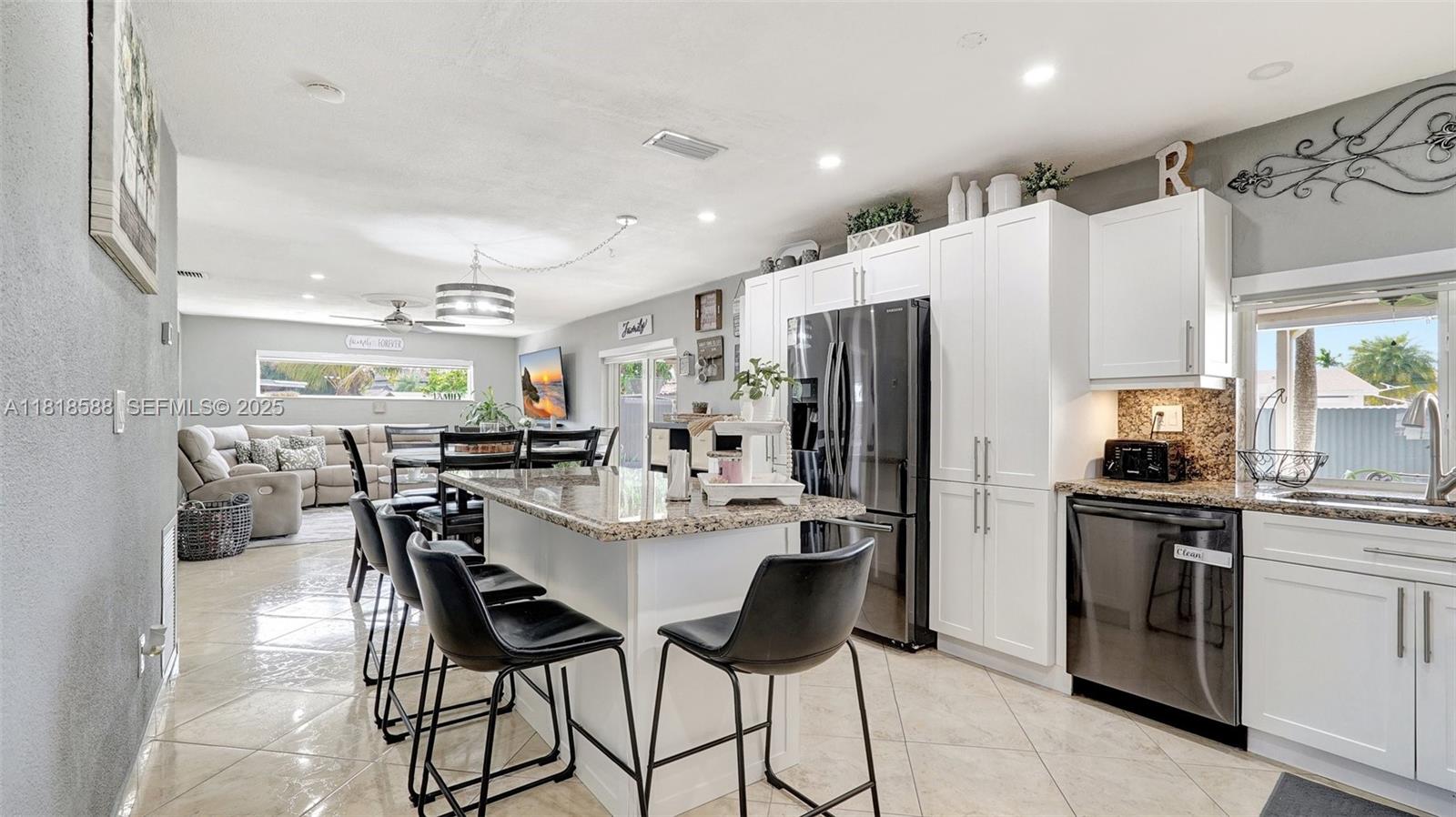 8540 Northwest 182nd Street Hialeah, FL 33015 - Photo 17 of 63 a kitchen with stainless steel appliances kitchen island granite countertop a refrigerator and a stove top oven