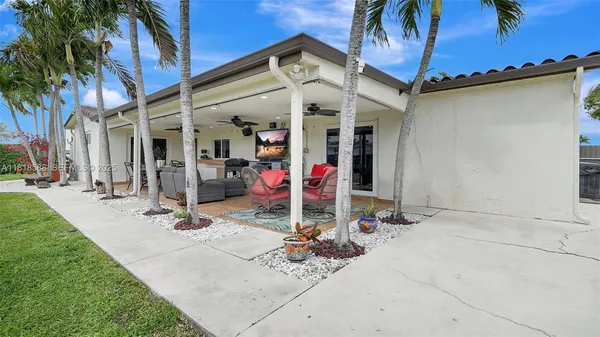 a view of a patio with table and chairs and potted plants with wooden floor and fence