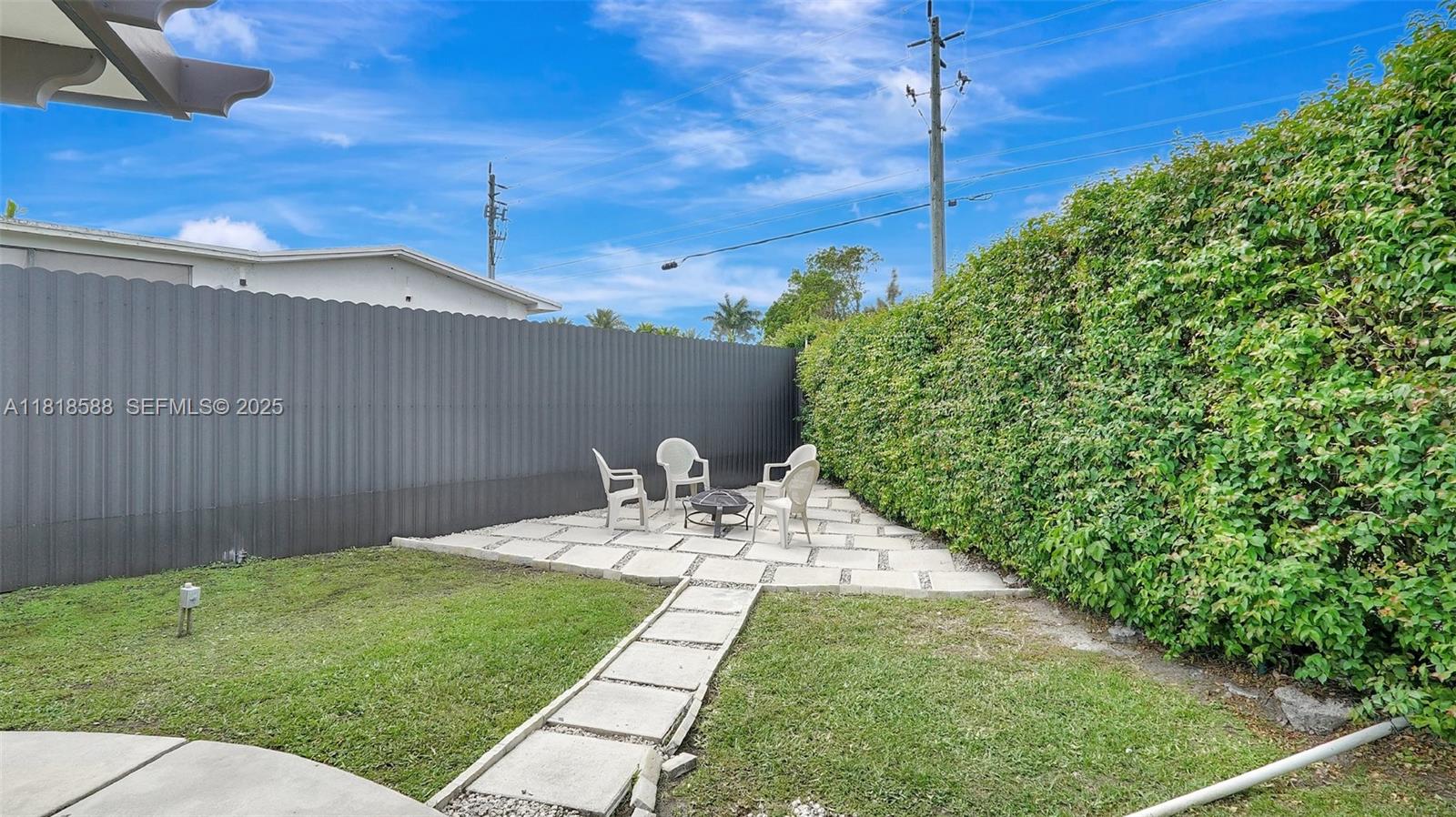 8540 Northwest 182nd Street Hialeah, FL 33015 - Photo 47 of 63 a view of a backyard with table and chairs and wooden fence