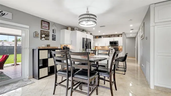 a kitchen with kitchen island a appliances dining table and chairs