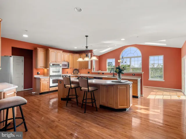 a kitchen with stainless steel appliances granite countertop a table chairs stove a refrigerator and cabinets