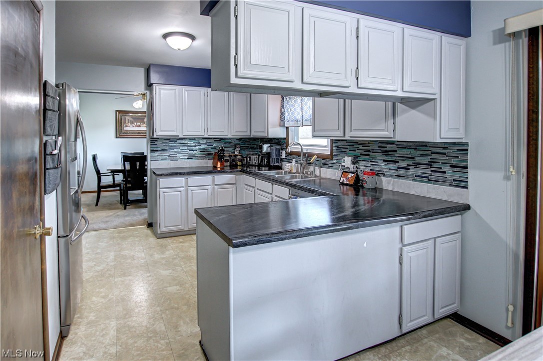 39353 Burns Road North Ridgeville, OH 44039 - Photo 4 of 35 Kitchen with countertops dark, washbasin, ceiling fan, kitchen peninsula, and white cabinetry