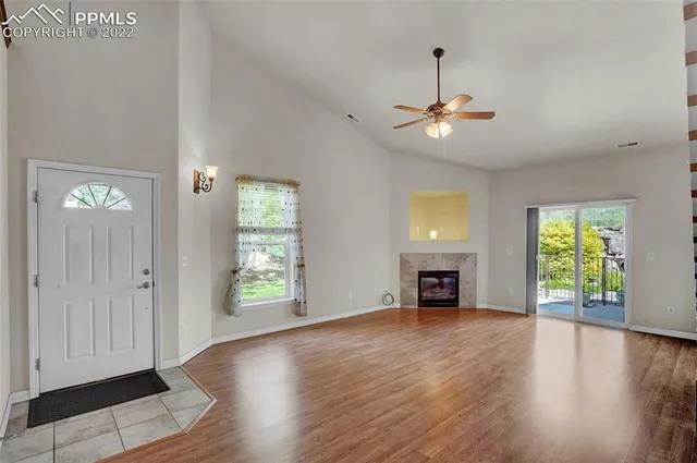 an empty room with windows and fireplace