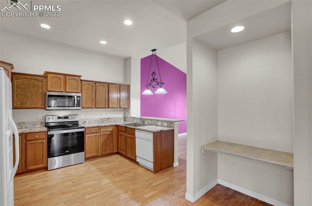 6578 Bethesda Point, Unit B Colorado Springs, CO 80918 - Photo 20 of 45 a kitchen with stainless steel appliances granite countertop a stove sink and microwave