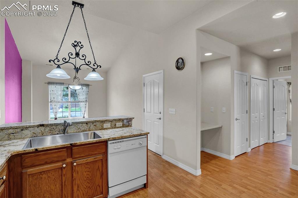 6578 Bethesda Point, Unit B Colorado Springs, CO 80918 - Photo 22 of 45 a kitchen with granite countertop a sink cabinets and wooden floor