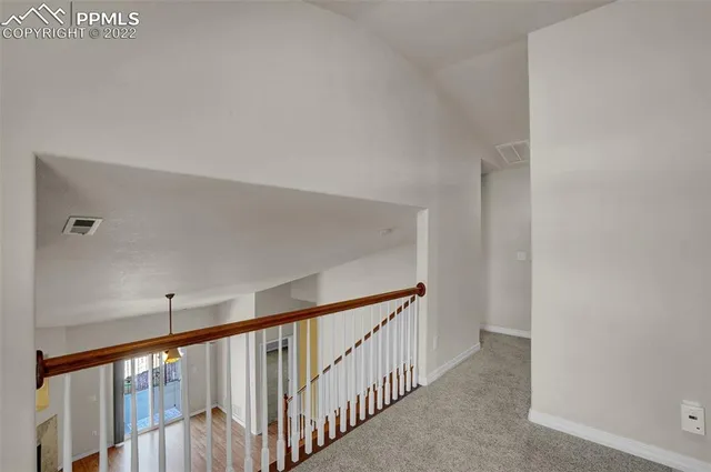 a view of a hallway with wooden floor and entryway