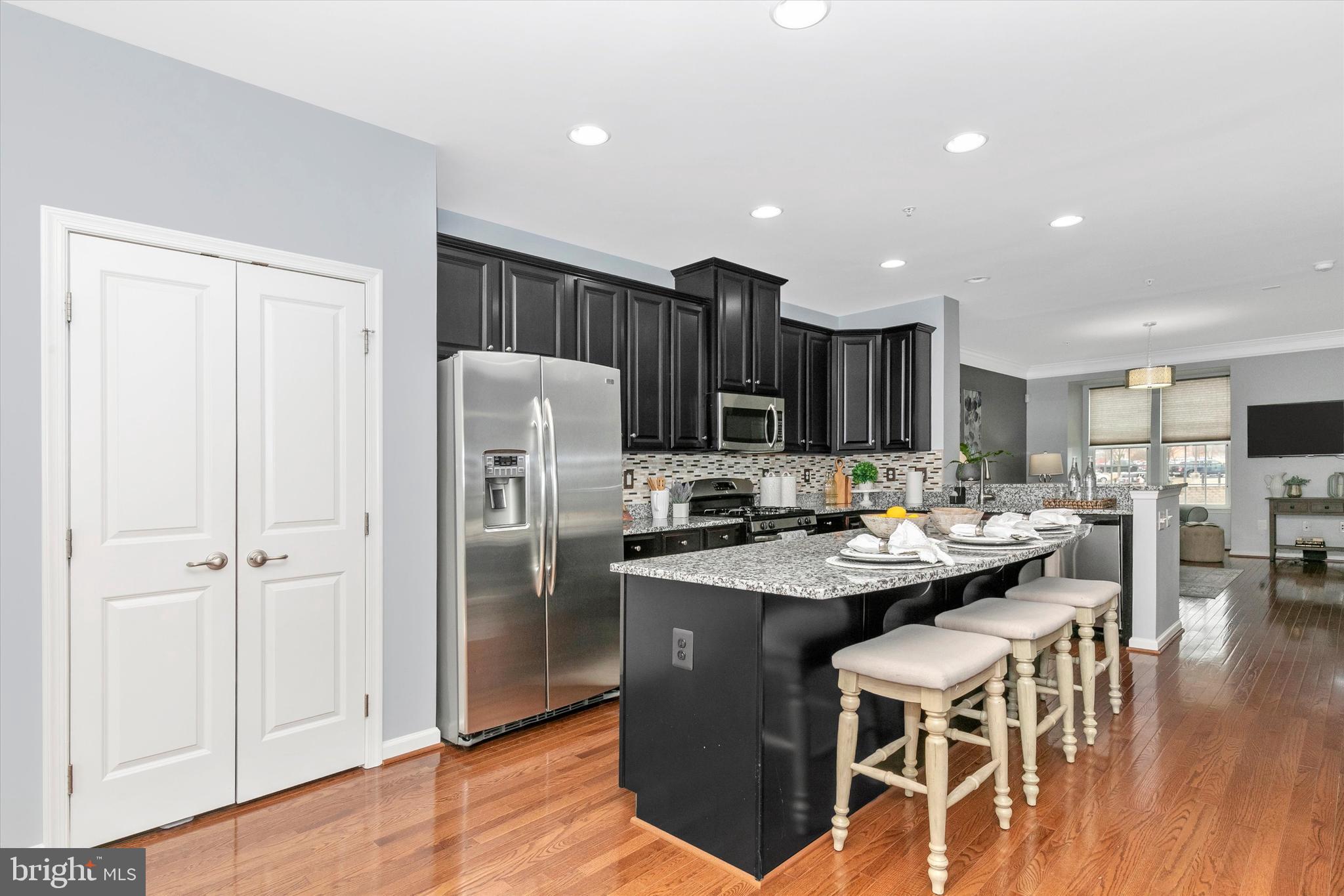 7821 Wormans Mill Road Frederick, MD 21701 - Photo 14 of 44 a kitchen with stainless steel appliances kitchen island granite countertop a refrigerator and a stove top oven