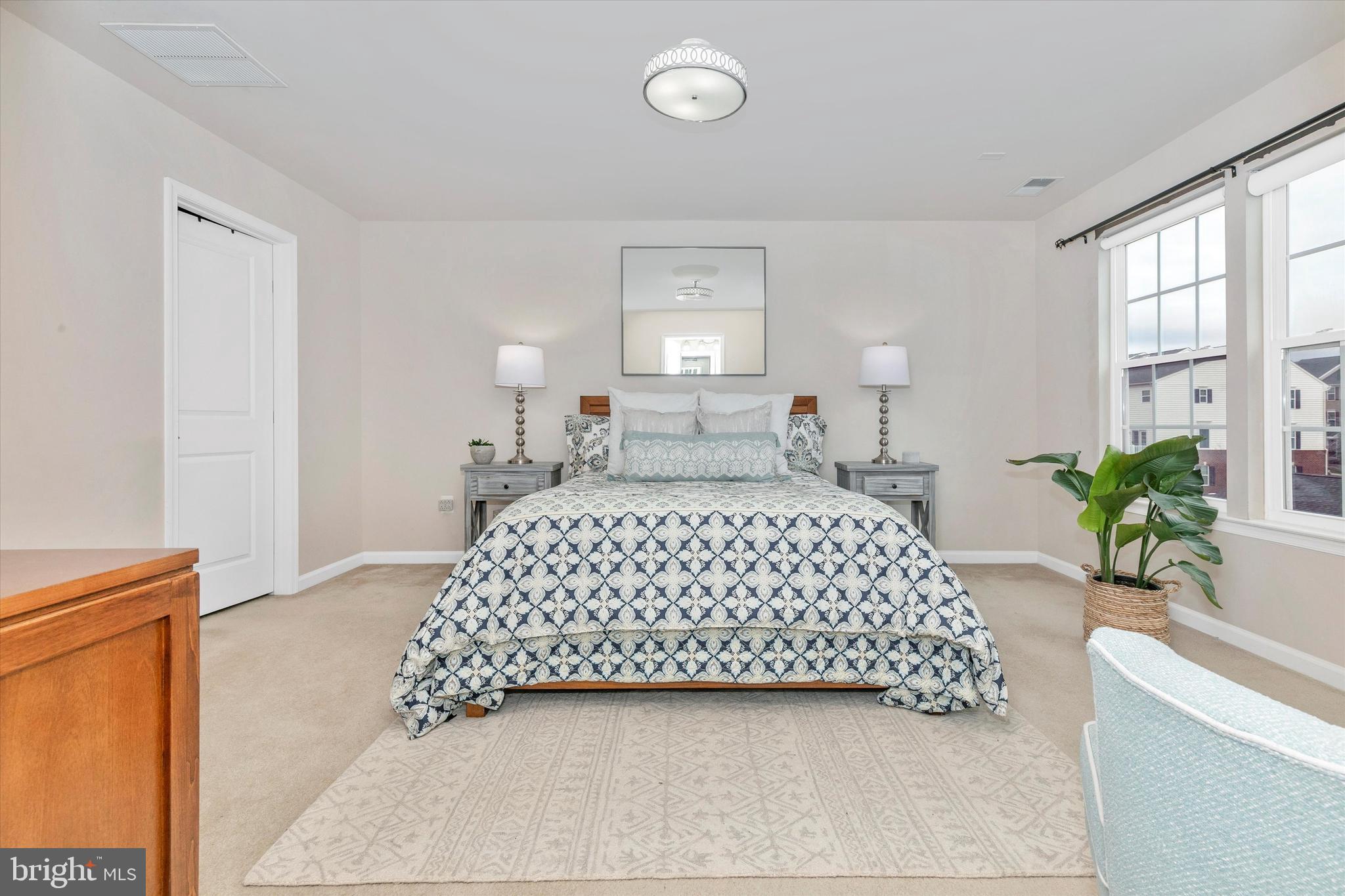 7821 Wormans Mill Road Frederick, MD 21701 - Photo 26 of 44 a bedroom with a large bed and a potted plant