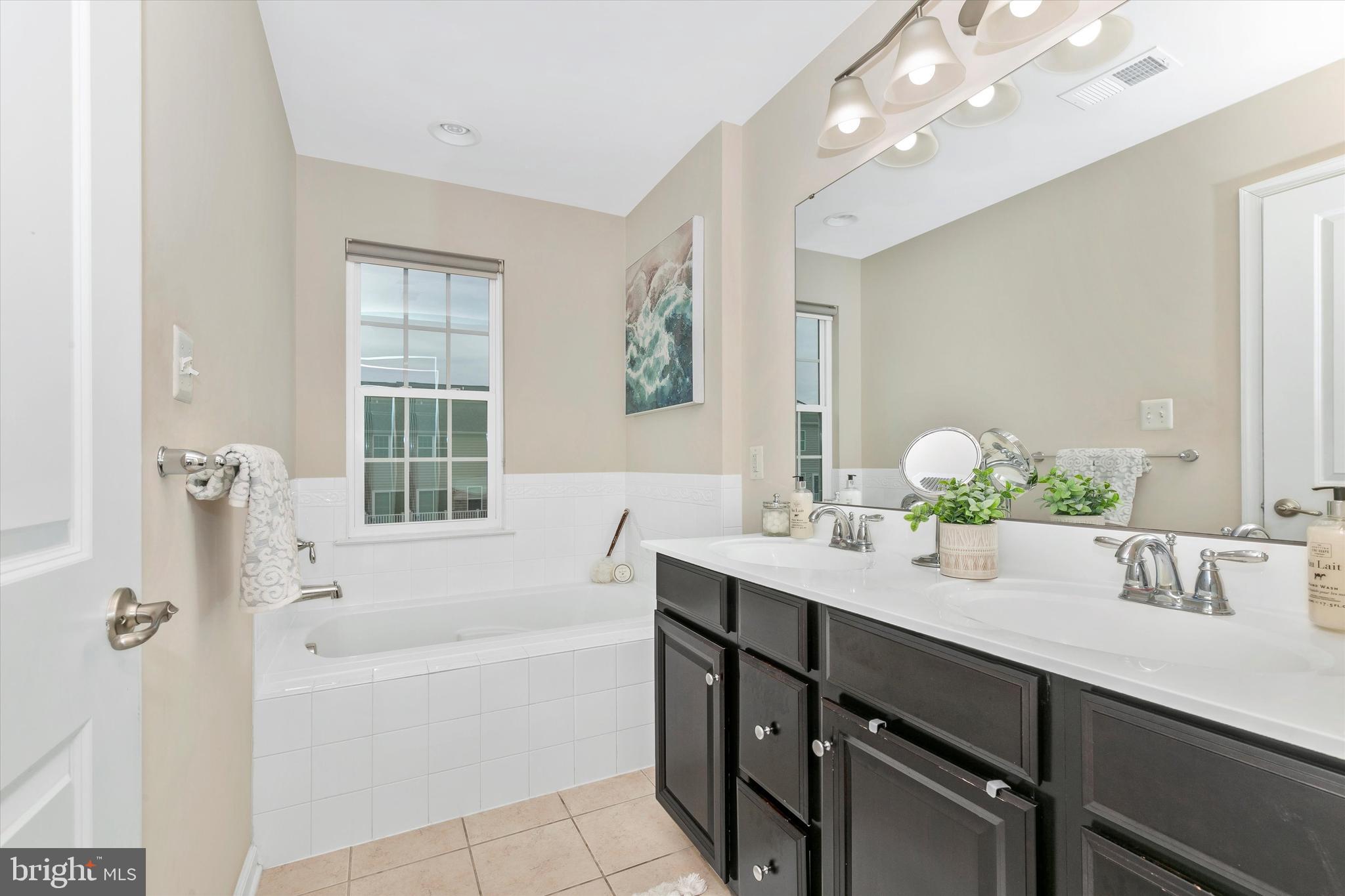 7821 Wormans Mill Road Frederick, MD 21701 - Photo 28 of 44 a bathroom with a tub a sink double vanity and a mirror