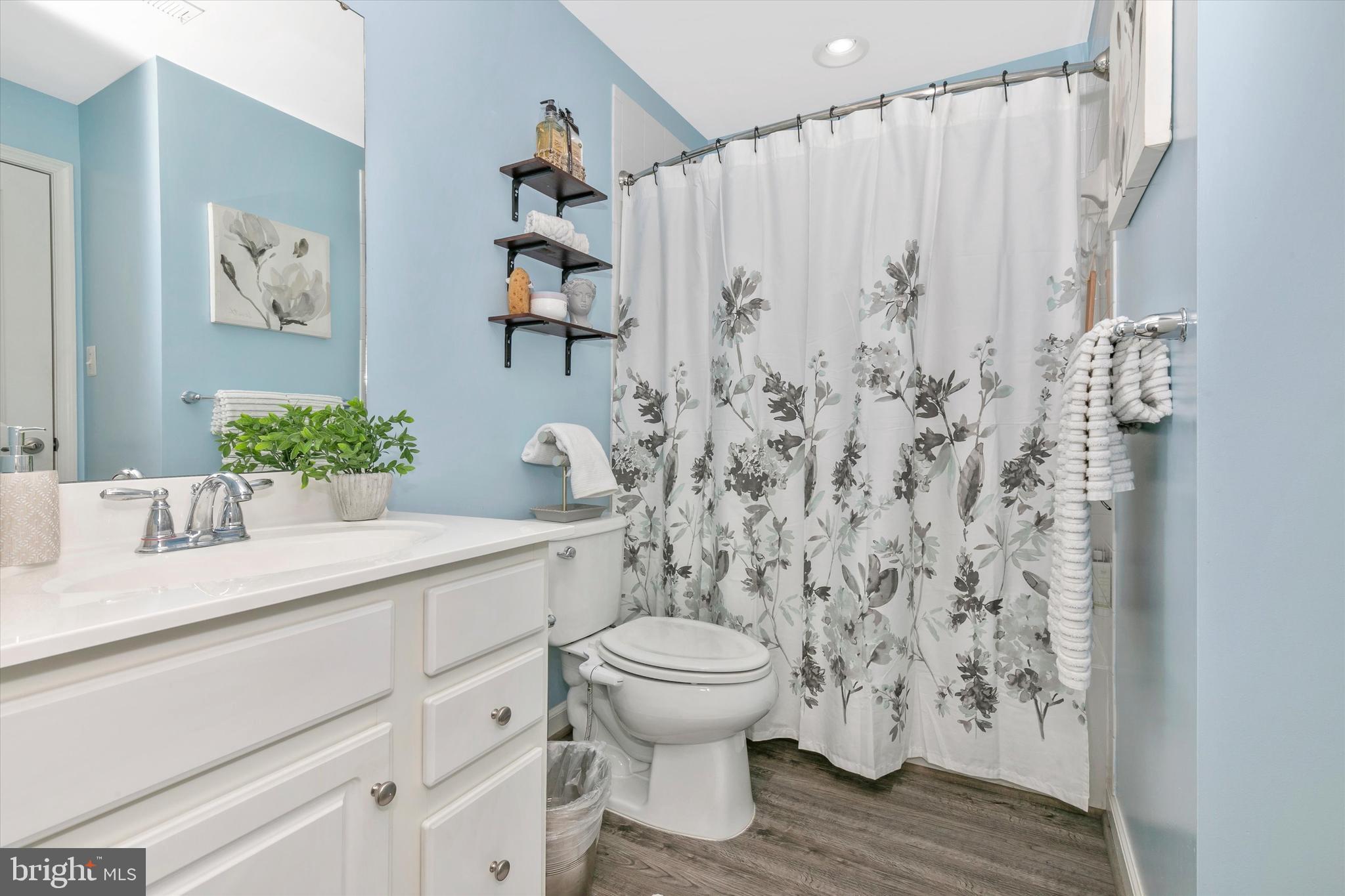 7821 Wormans Mill Road Frederick, MD 21701 - Photo 9 of 44 a bathroom with a granite countertop sink a toilet and a shower curtain