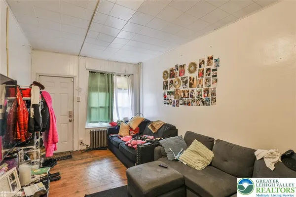 a living room with furniture a flat screen tv and a window