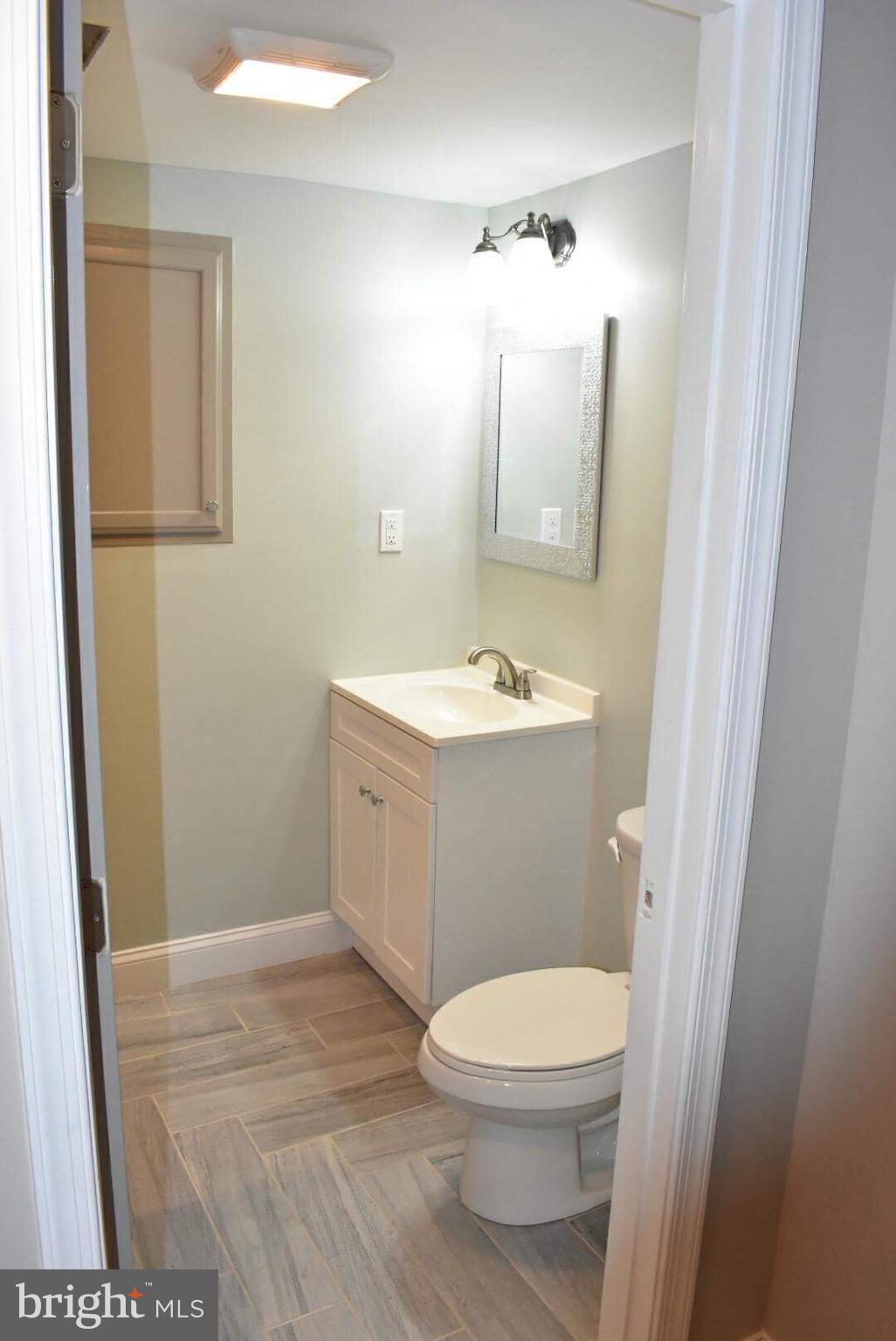 238 Pinewood Road Baltimore, MD 21222 - Photo 11 of 22 a bathroom with a toilet a sink and mirror