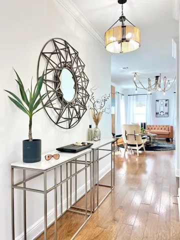 a living room with furniture a chandelier and a dining table