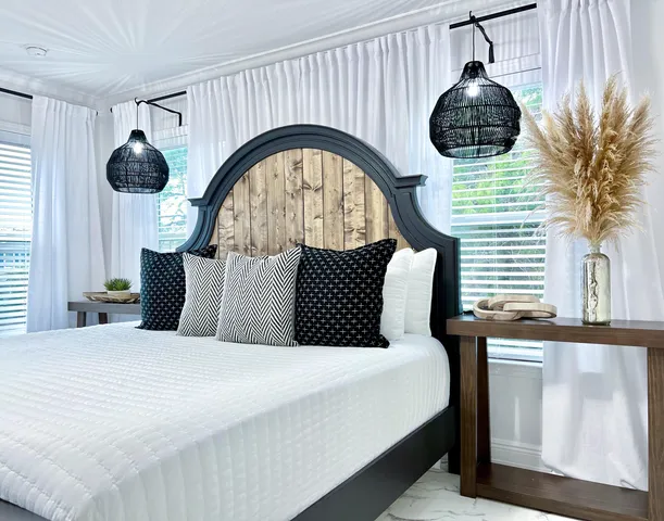 a bed room with a bed a lamp and a large window