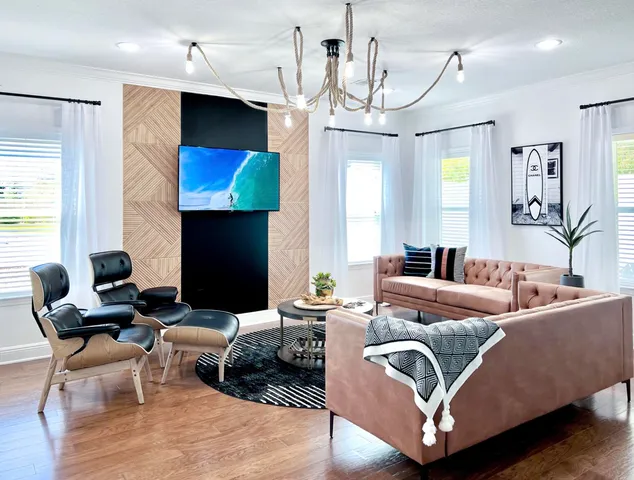 a living room with furniture a large window and a chandelier