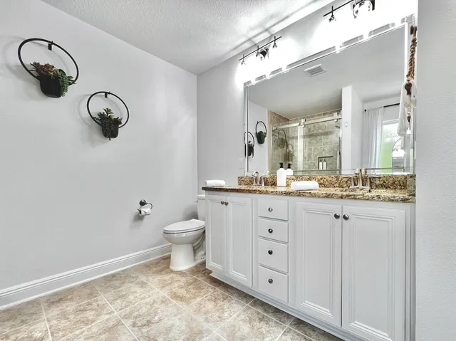 a bathroom with a toilet a sink and mirror