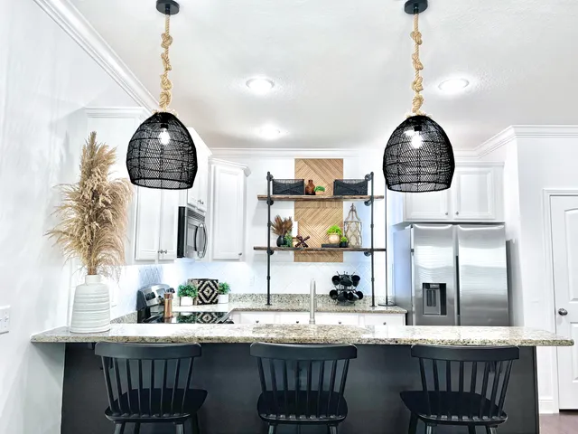 a kitchen with granite countertop a sink a counter space a clock and cabinets