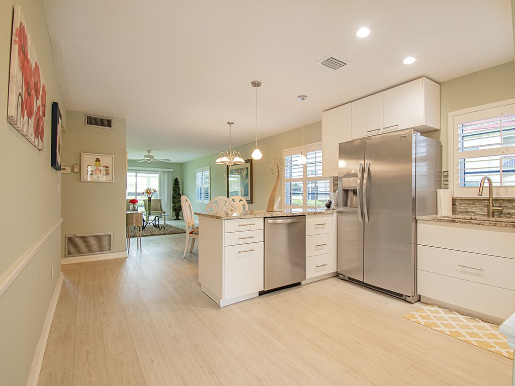 Undisclosed Address Vero Beach, FL 32962 - Photo 4 of 31 a kitchen with white cabinets and stainless steel appliances