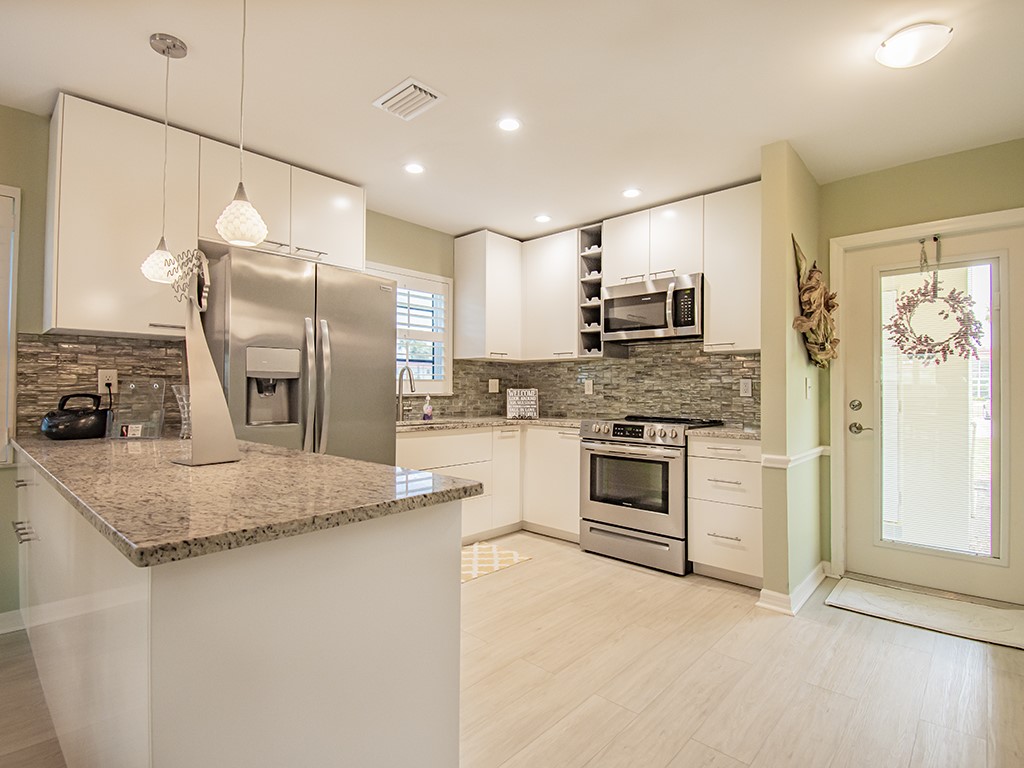 Undisclosed Address Vero Beach, FL 32962 - Photo 5 of 31 a kitchen with stainless steel appliances granite countertop a stove a sink and a refrigerator