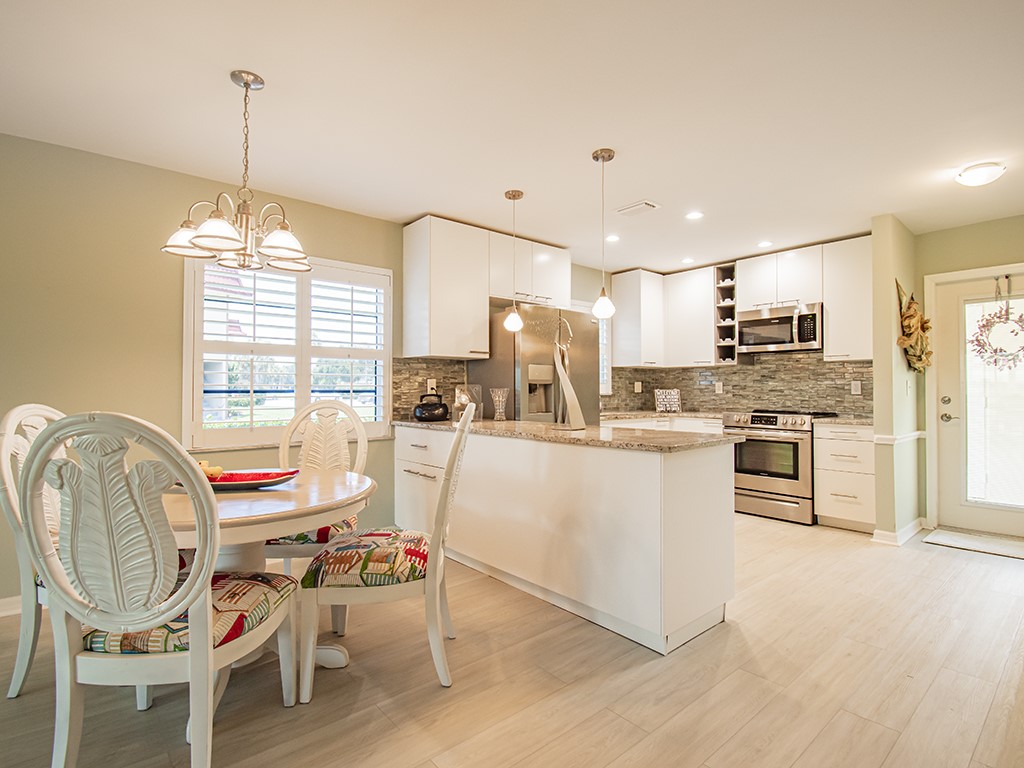 Undisclosed Address Vero Beach, FL 32962 - Photo 6 of 31 a kitchen with a refrigerator a stove cabinets and dining table