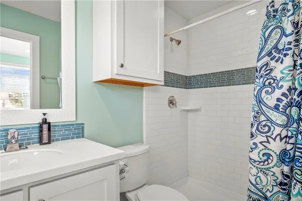 a bathroom with a sink and mirror with toilet