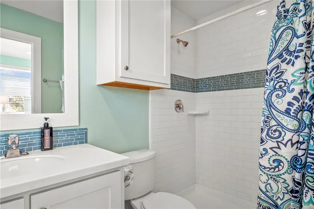 a bathroom with a sink and mirror with toilet
